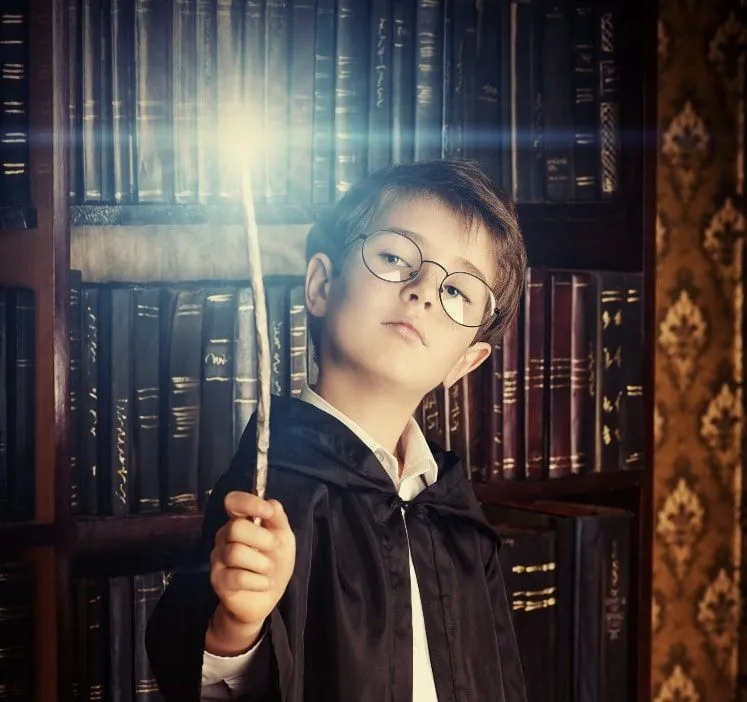Young boy dressed as Harry Potter testing out a wand in the shop.