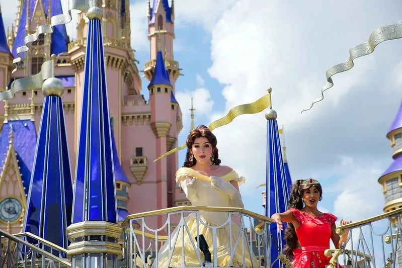 Princess Belle, from 'Beauty and the Beast', standing in front of the Disney castle.
