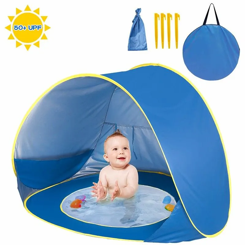 A baby paddling in the Shayson Pop Up Beach Tent.