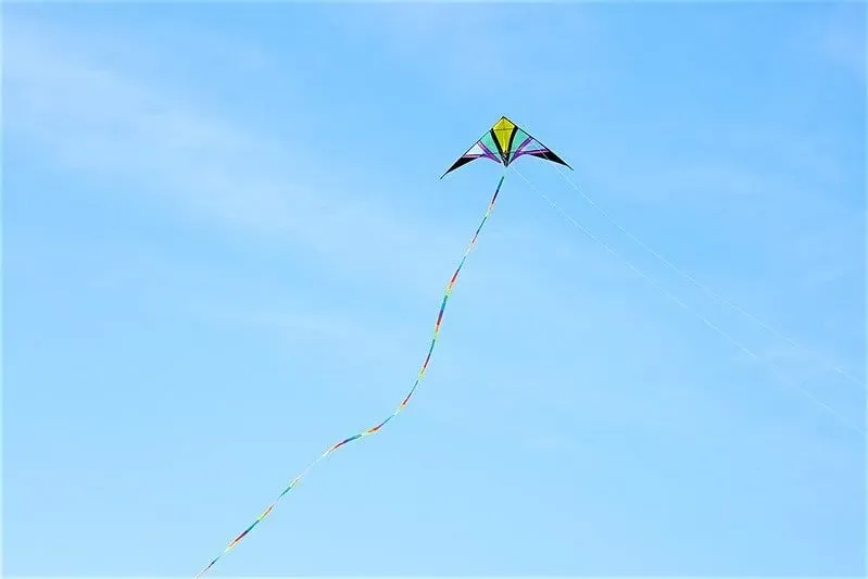 A multi-coloured kite flying high in a blue sky.