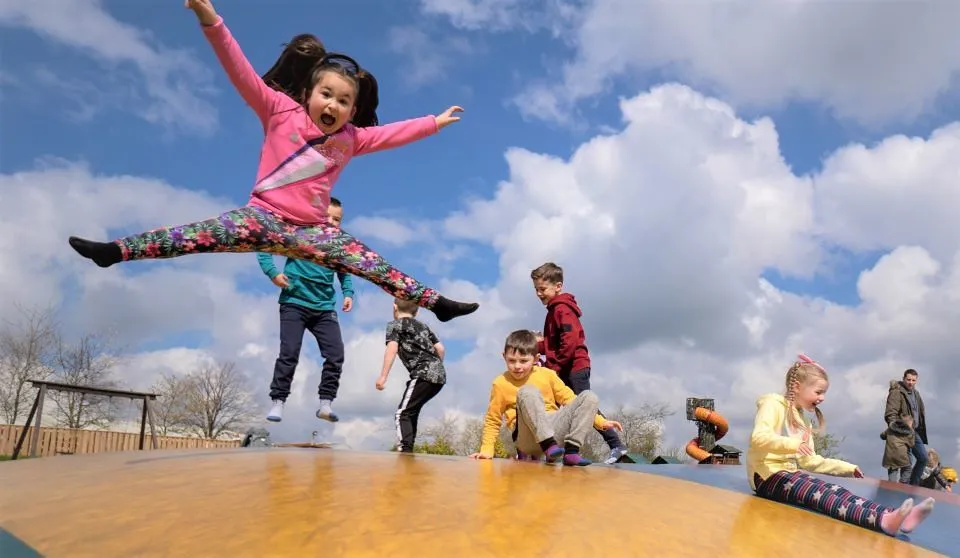 Kids jumping for joy and playing on a day out in Cardiff.