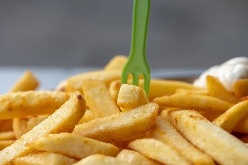 Pile of chips with a green plastic fork stuck in them.