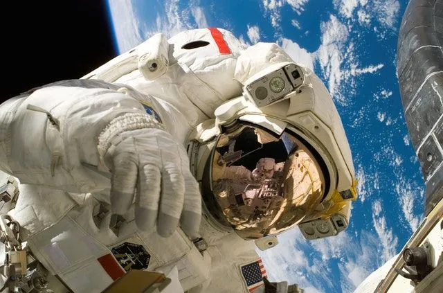 An astronaut in outer space with the Earth in view behind them. 