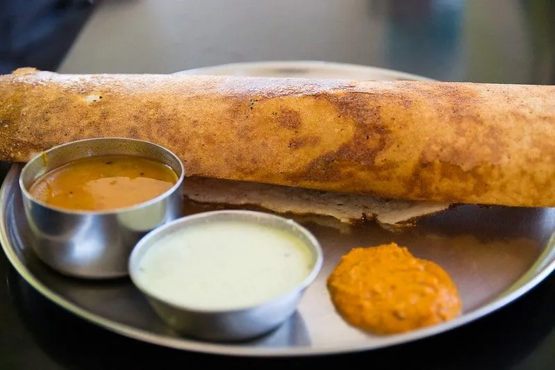 Plate of masala dosa with all the accompanying dishes and sauces.