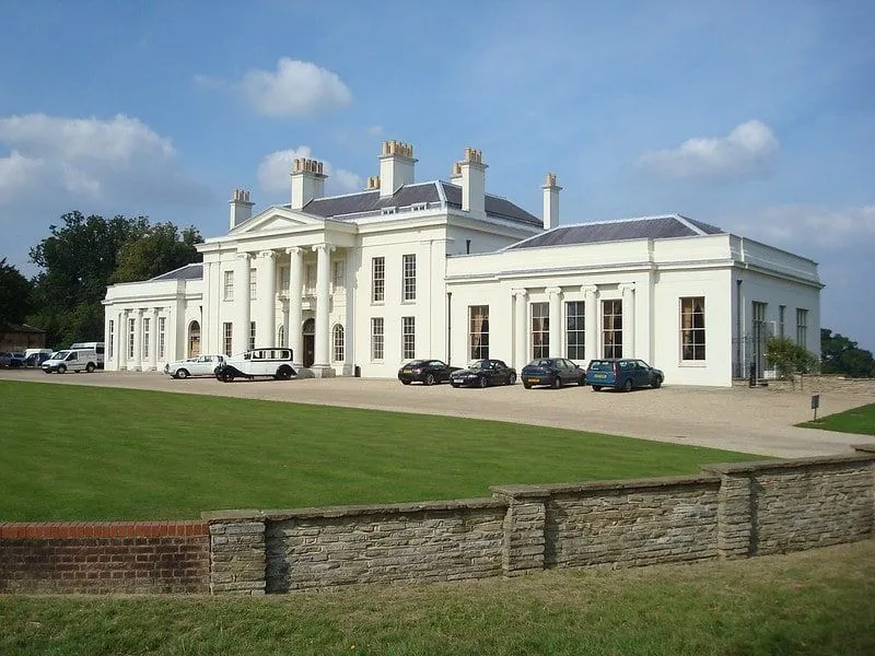 A front view of the Hylands Estate park house, a cream exterior with columns outside the front door.