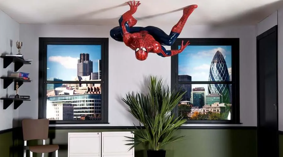 A model of Marvel's Spiderman crouching on the ceiling of a London office.
