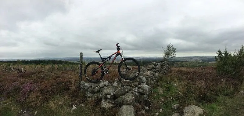 A bike on a rock wall in the countryside at Kirkhill Forest.