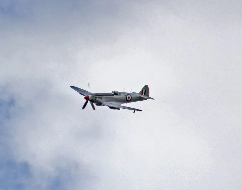 WW2 RAF fighter plane flying through the sky.