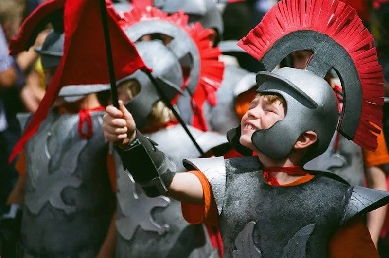 Young boy wearing a Roman soldier outfit with a helmet.