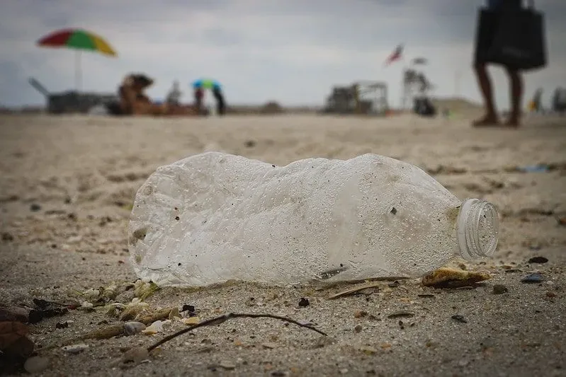 Plastic bottle discarded in the sand on the beach.