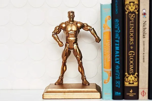 A gold man action figure as a bookend.