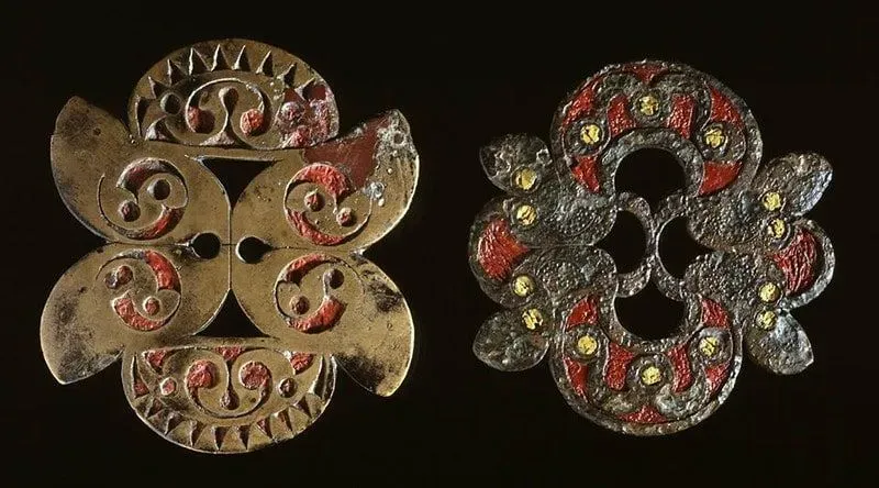 Two metal brooches from the Iron Age, showing off detailed metal work.