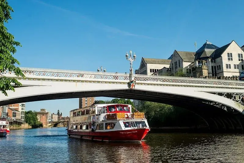 A City Cruises vessel going under a bridge on the River Ouse. 