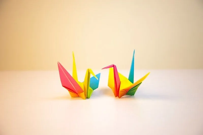 Two multi-coloured origami birds on the tabletop.