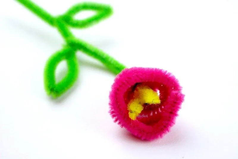 A dark pink rose on a stem, made out of a pipe cleaner. 