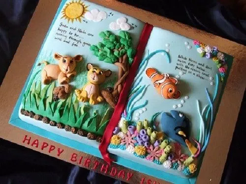 Book cake decorated with a scene from The Lion King on one page and from Finding Nemo on the other.