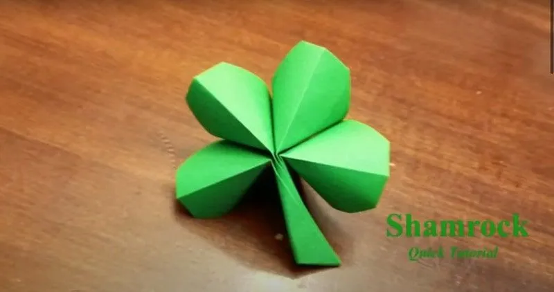 Origami four leaf clover on a wooden table.