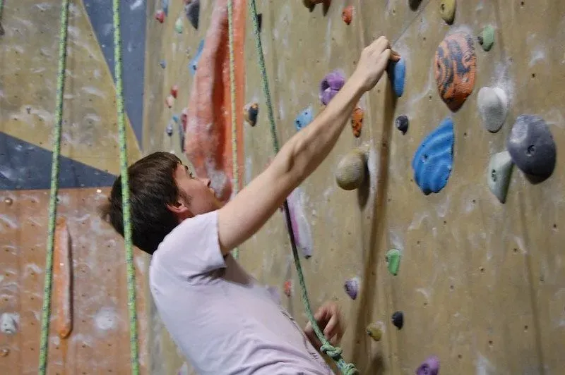 Teenage boy scaling the rock wall at Cambridge Clip And Climb.