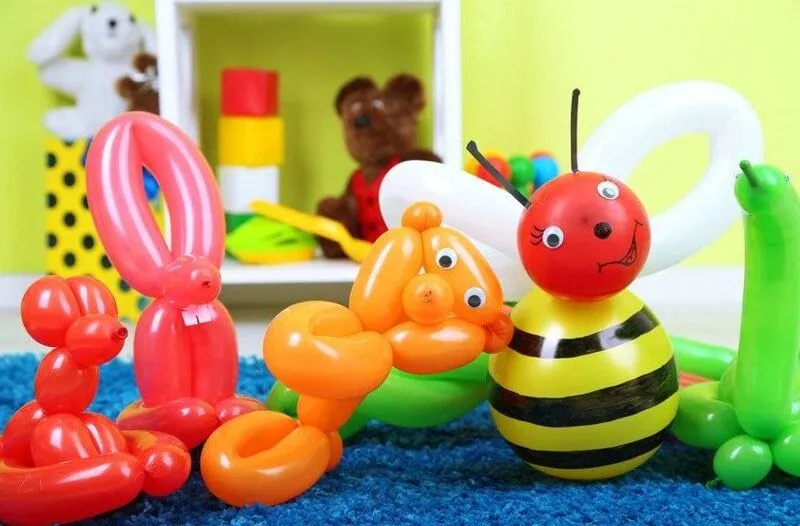 Various balloon animals, including a bee, lined up next to each other.