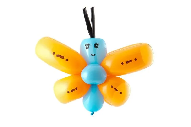 Balloon butterfly made from an orange and blue balloon with a face drawn on.