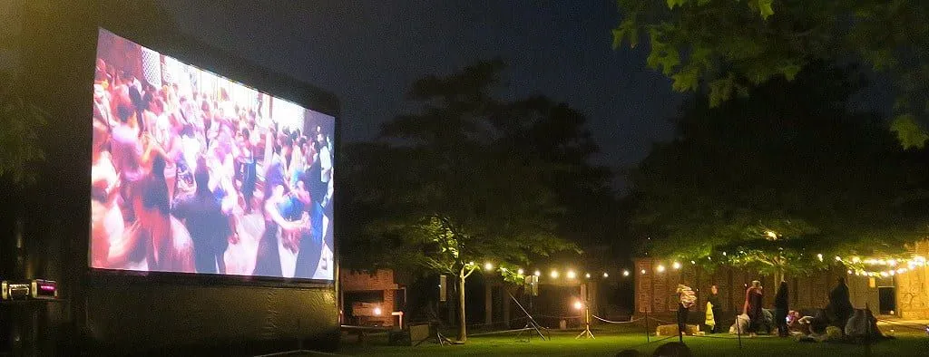 The large screen showing a ballroom scene in a movie at Moonbeamers Drive In Cinema.