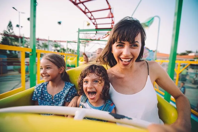Mum and two daughters having fun on a rollercoaster.