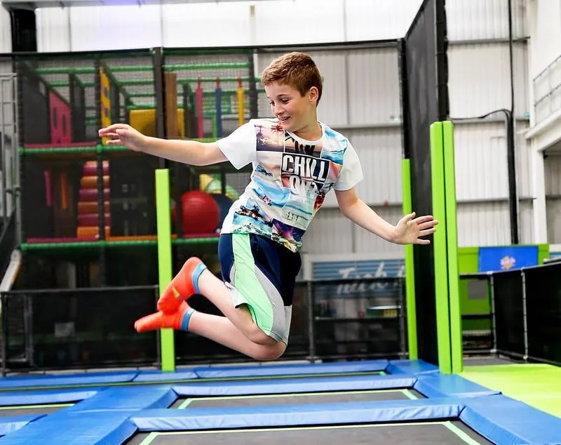 Young boy posing in the air as he bounces at Jump In trampoline park.
