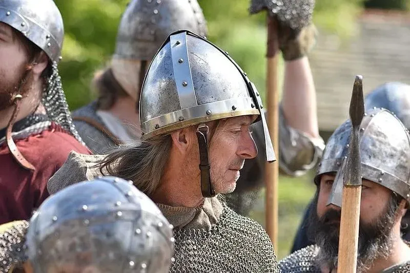 Close up of a Viking warrior, wearing a metal helmet and armour.