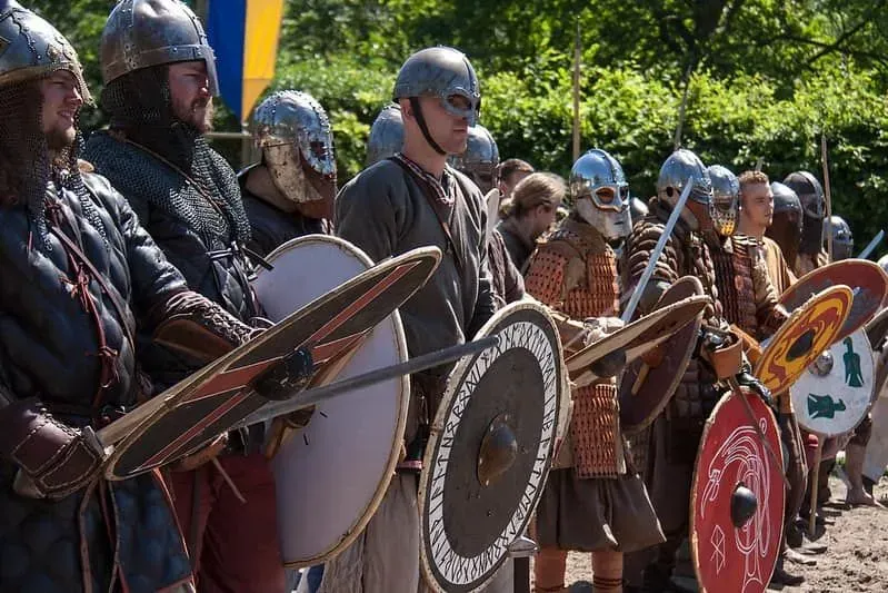 A Viking army of men wearing armour and holding swords and shields.