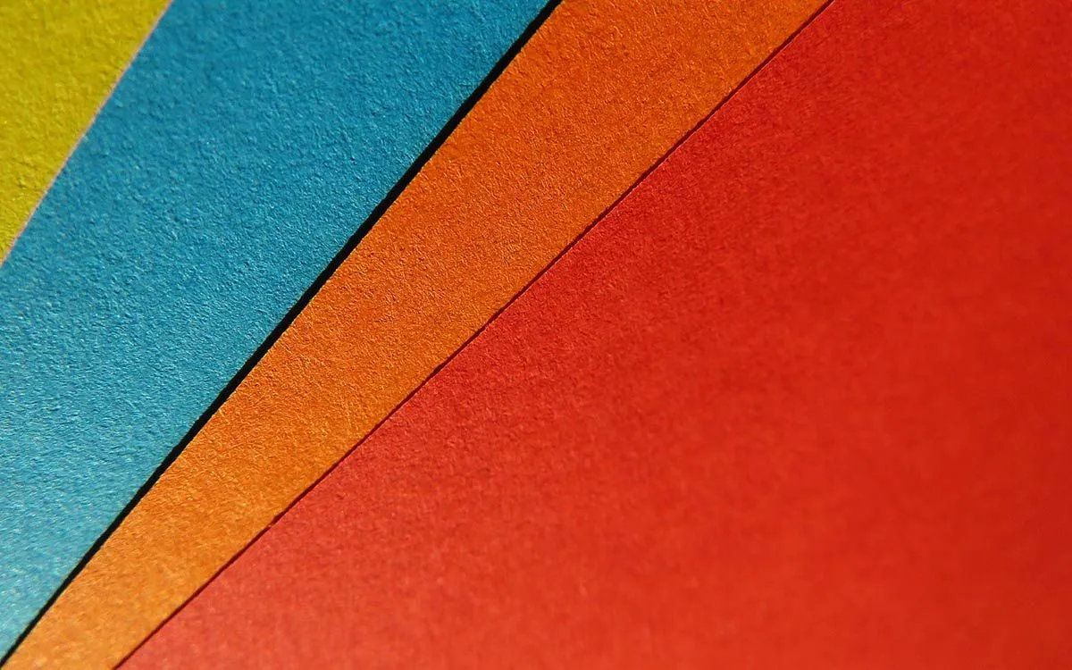 Pieces of different coloured textured paper fanned out.