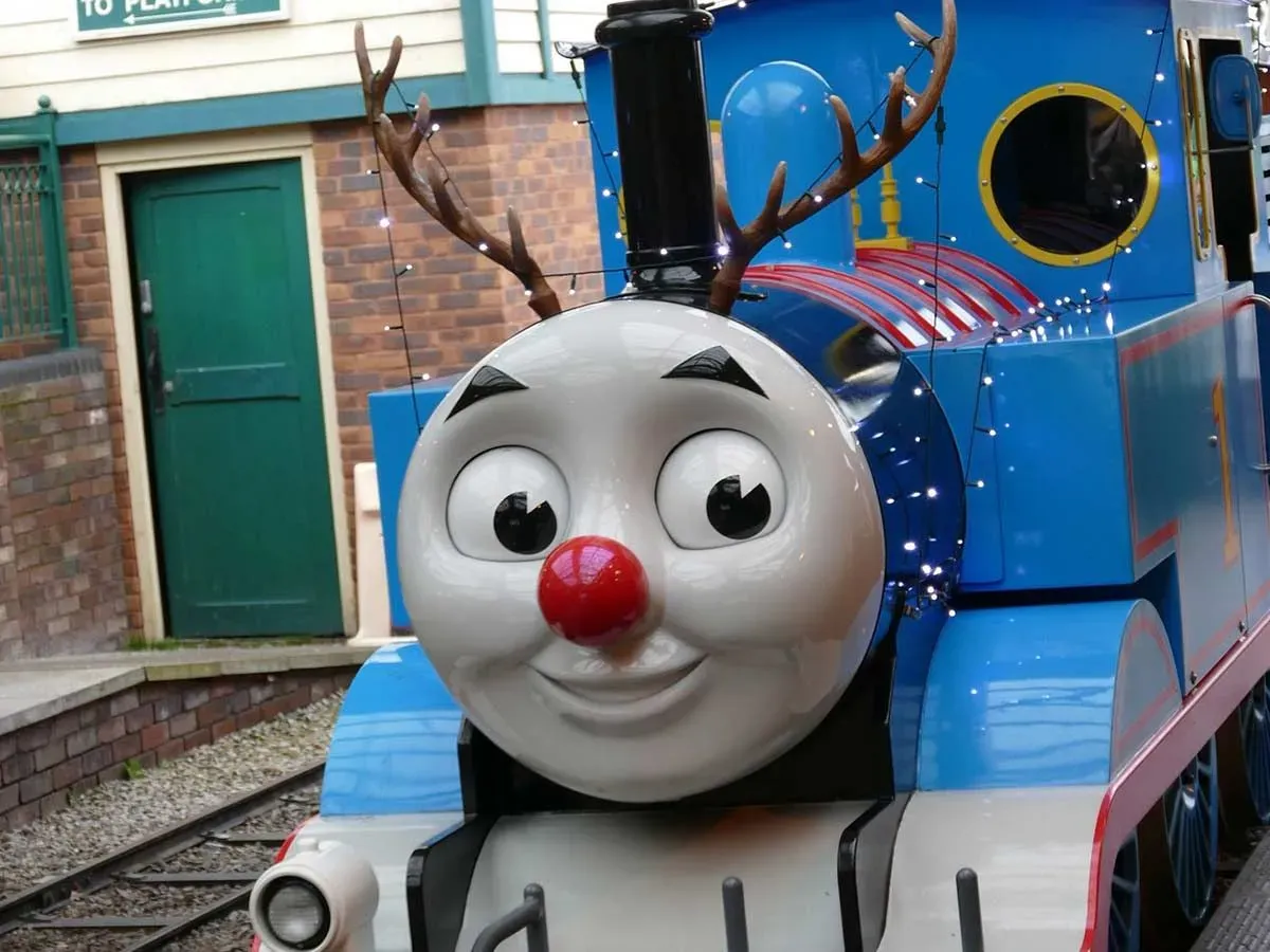 Thomas the Tank Engine model with antlers and fairy lights on it for Christmas.