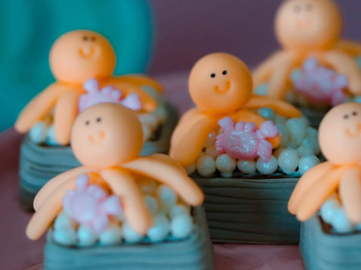 Little cakes decorated with squids made from icing on top.