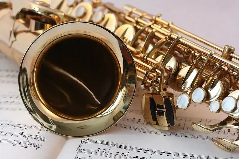 Close up of a saxophone on an open music book.