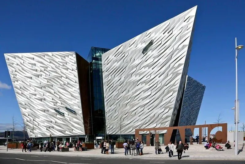 A front view of the Titanic Belfast with visitors near the entrance. 