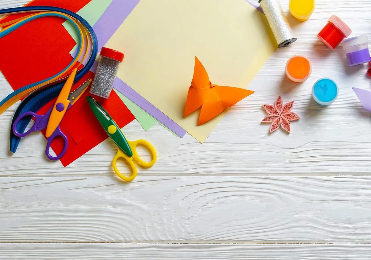 Art supplies to make origami on a table.