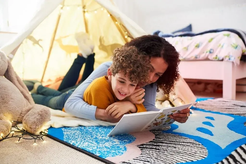 Mother reading with son in den in bedroom