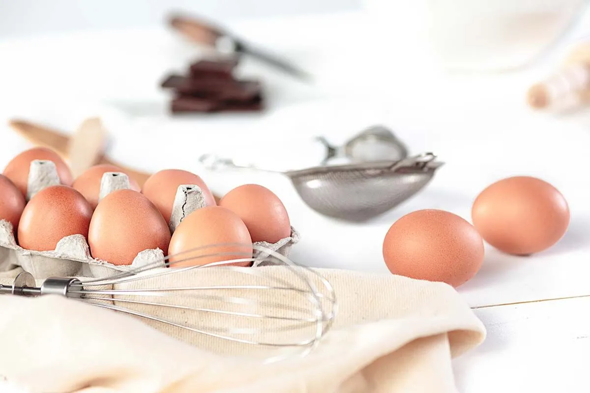 Eggs and a whisk on the kitchen counter ready to go into to batter for a giant Jaffa cake.