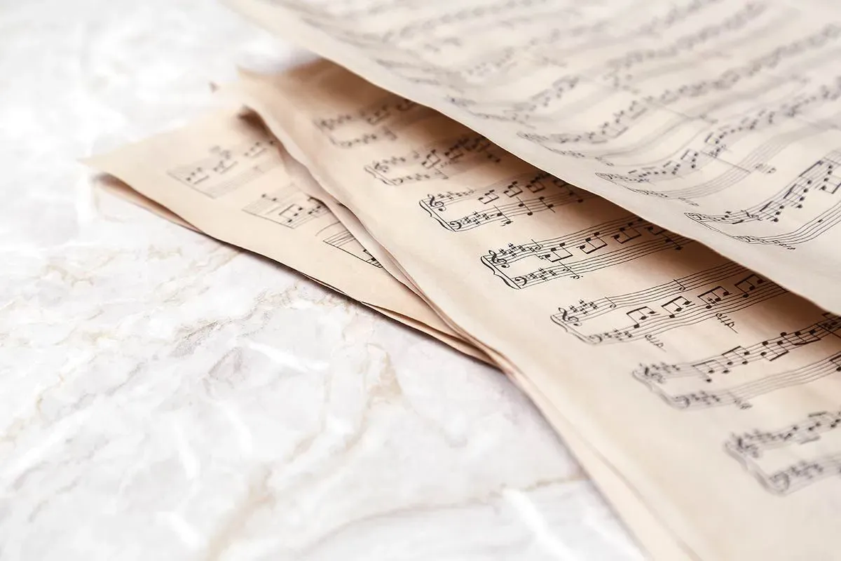 Sheets of music on a white marble surface.