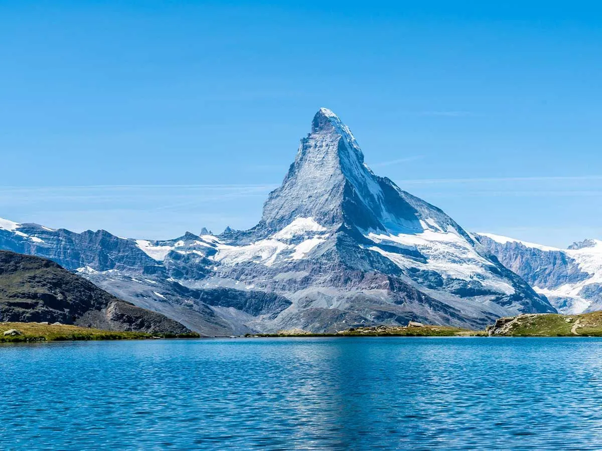 View of a lake in front of a large mountain in Switzerland.