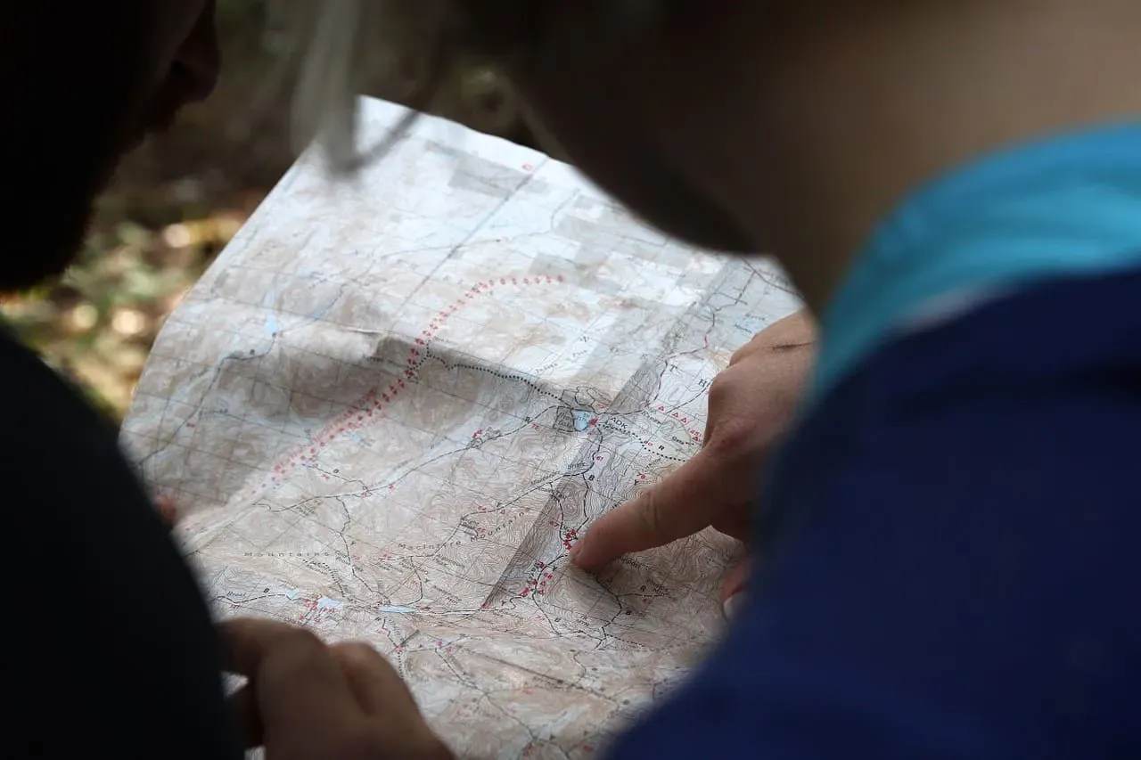 Child looking at a map pointing to a certain place, learning about types of settlements.
