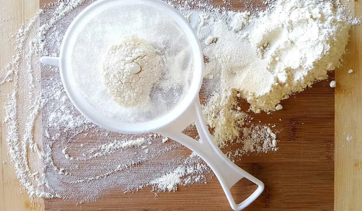 A close up image of a sieve filled with flour, one of the ingredients in the giant cupcake recipe.