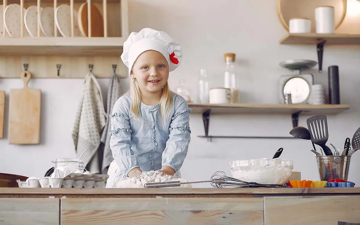 A little girl wearing a chef's hat is preparing ingredients for this giant cupcake recipe.