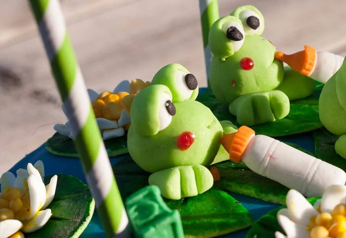 Frog toppers made from fondant icing make a fun addition to an animal-themed cake.