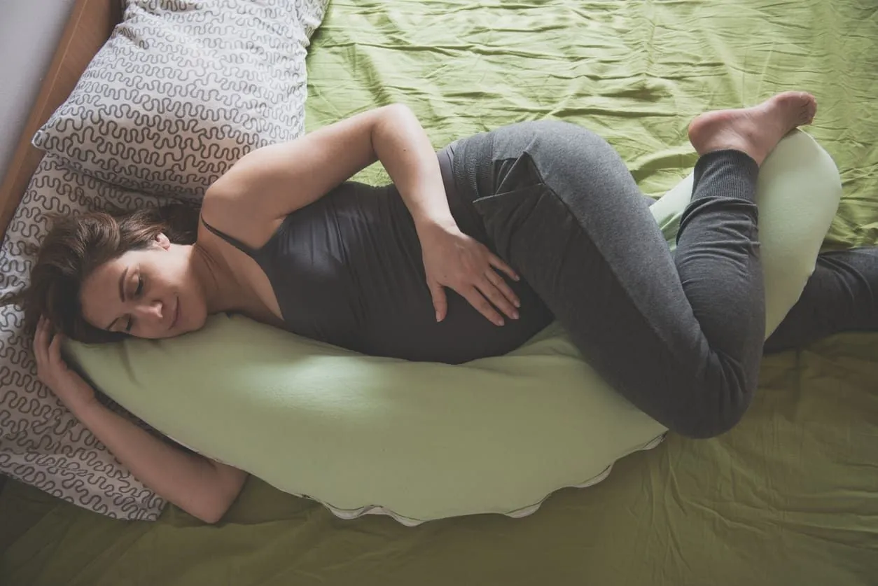 Pregnant woman using a pregnancy pillow