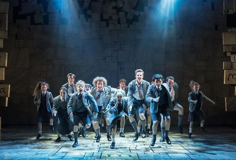 The child cast on stage at Matilda The Musical in a dance sequence.