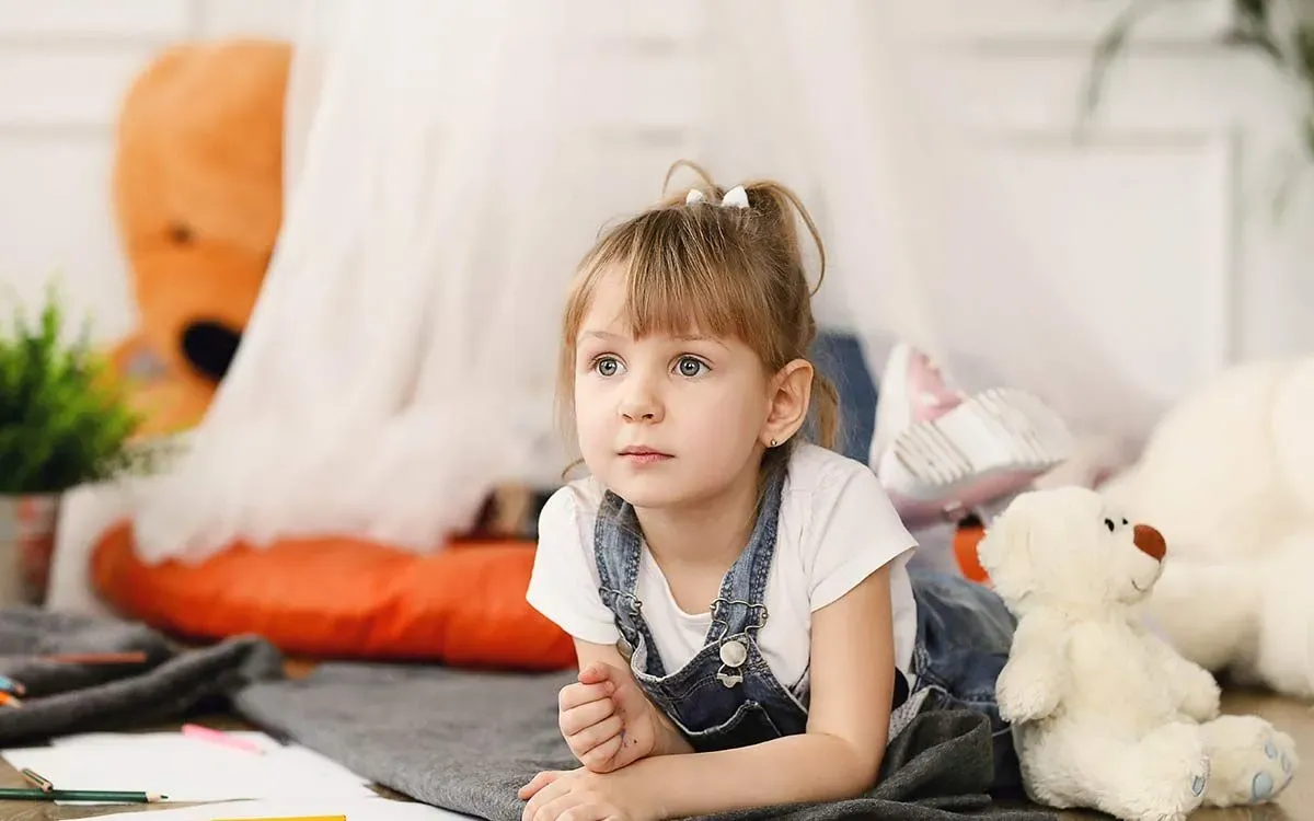 Little girl lying on the floor thinking about how to solves impossible riddles.