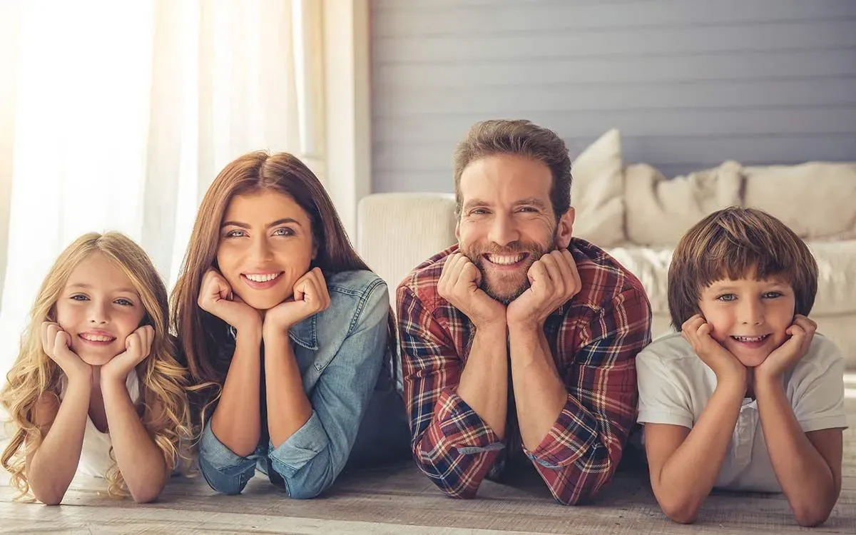 Family of four lying on the bed smiling at impossible riddles.