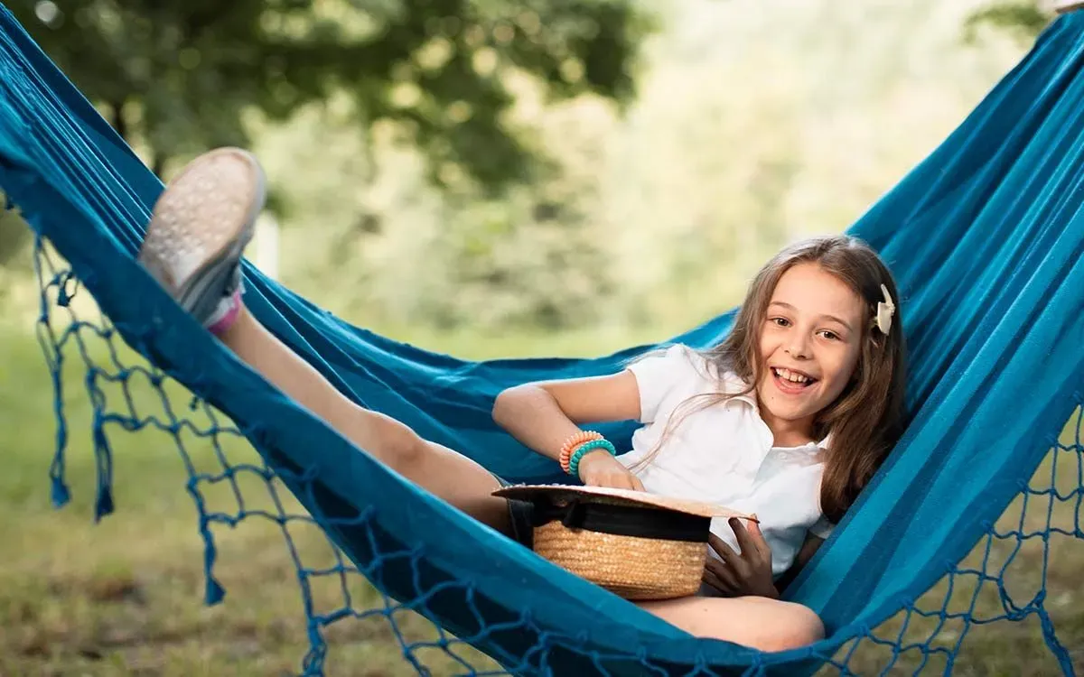 Young girl smiling as she lies in a hammock trying to solve impossible riddles.