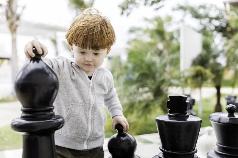 A child playing giant outdoor chess.