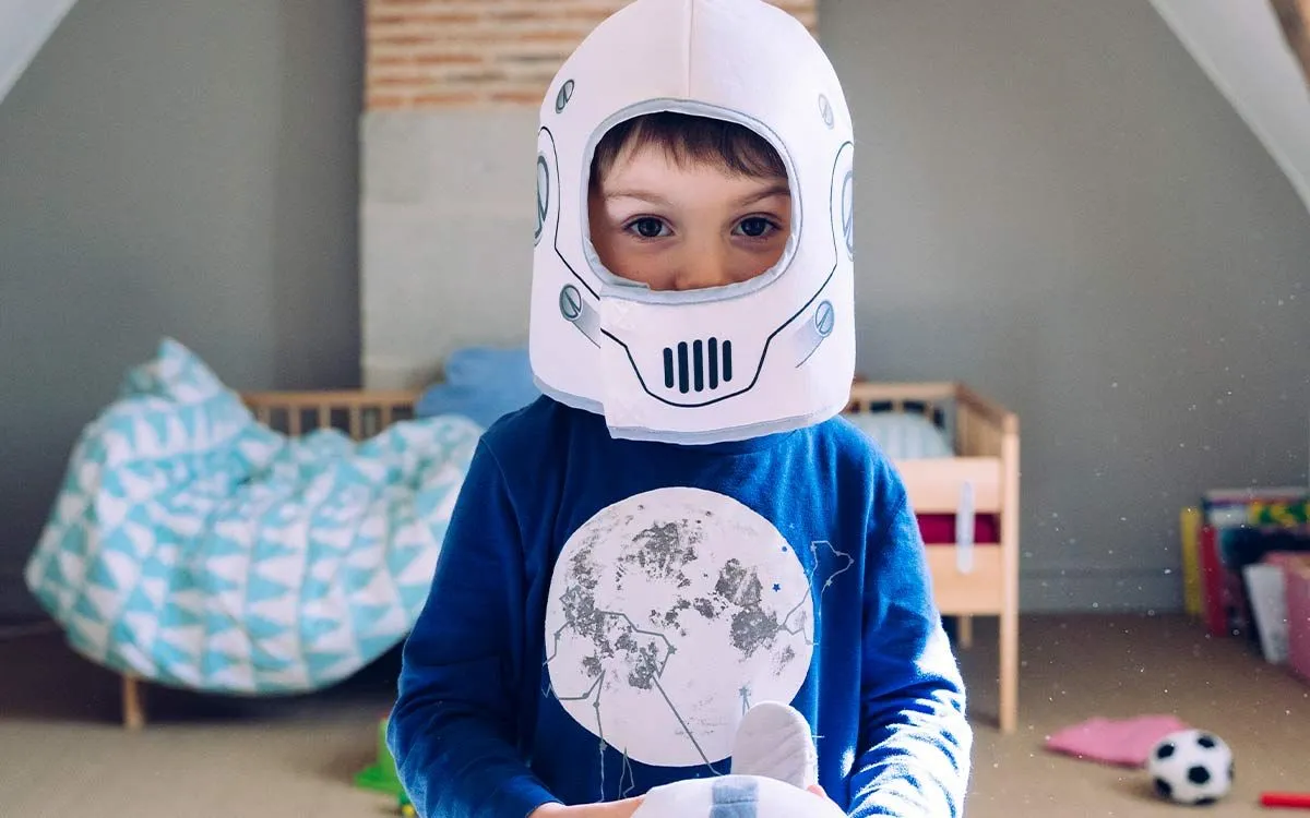 Boy wearing a homemade Stormtrooper helmet standing in his room waiting to hear Star Wars puns.